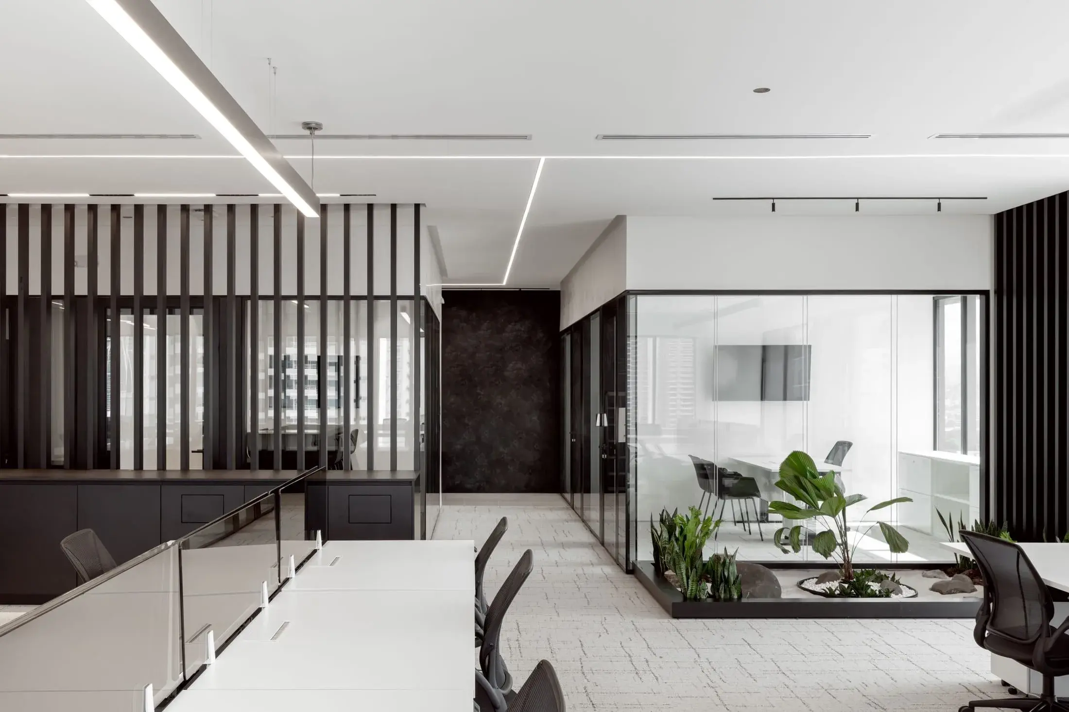 Oficina con divisiones de vidrio y jardín interior