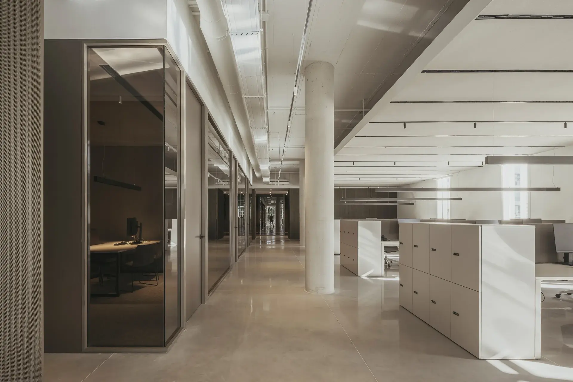 Pasillo de oficina con divisiones de vidrio y piso claro